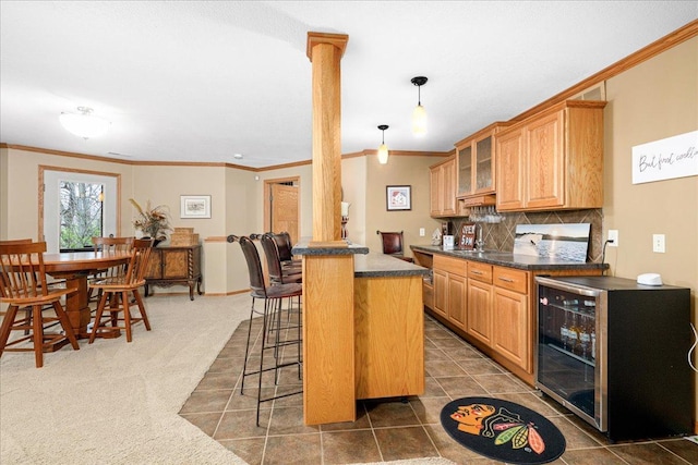 2222 White Oak Ct, Hudson, WI 54016 - kitchen with ornamental molding, dark countertops, a breakfast bar, beverage cooler, and tasteful backsplash