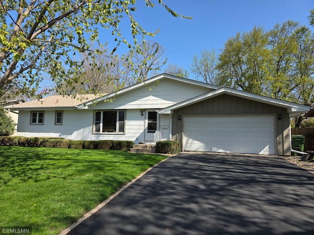 single story home with driveway, a garage, and a front yard