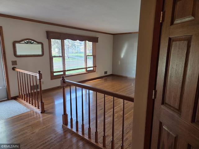 interior space with crown molding, baseboards, dark wood-style flooring, and an upstairs landing