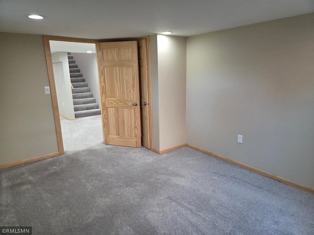carpeted empty room featuring recessed lighting, baseboards, and stairs