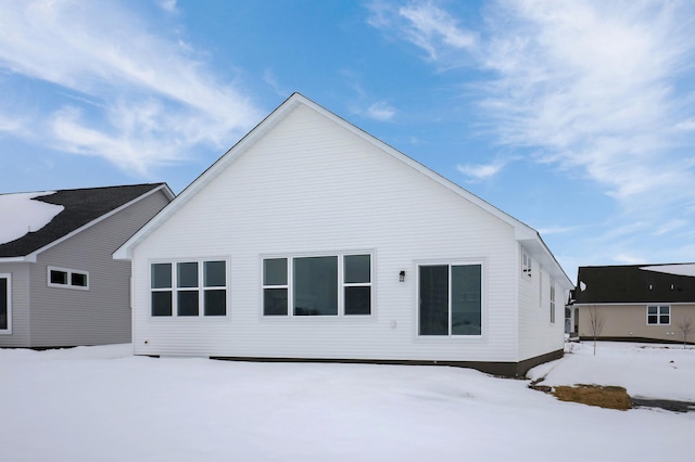 view of snow covered back of property