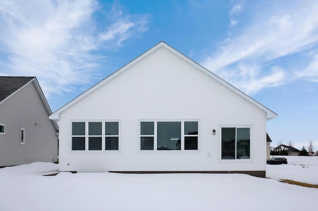 view of snow covered back of property