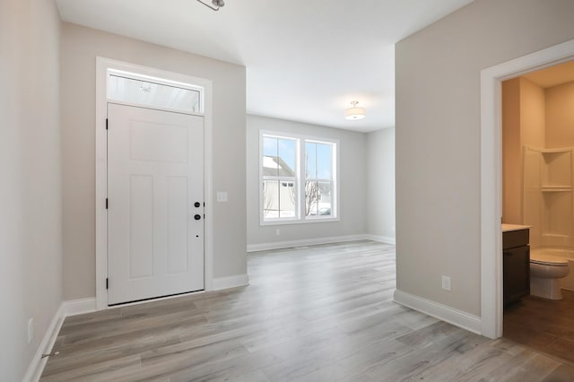 entryway with baseboards and light wood finished floors