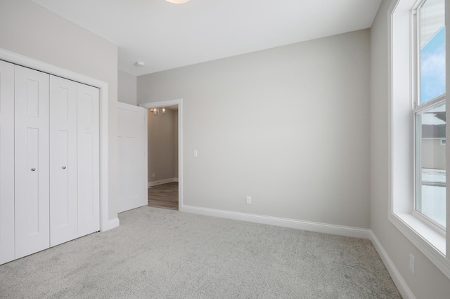 unfurnished bedroom featuring a closet, carpet, and multiple windows