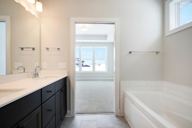 full bathroom with double vanity, a sink, a bath, and tile patterned floors