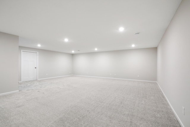 unfurnished room with recessed lighting, baseboards, and light carpet