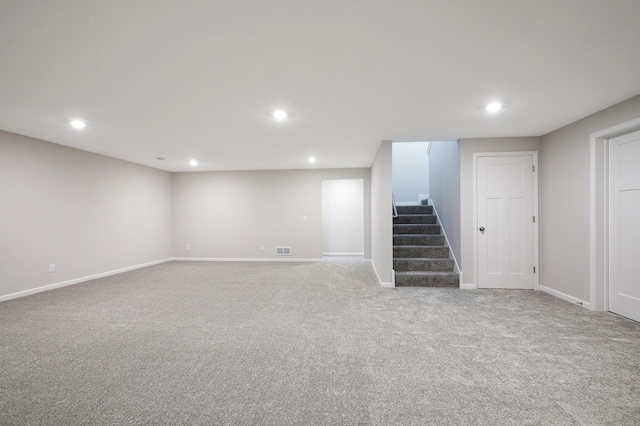 finished basement with recessed lighting, visible vents, and stairway