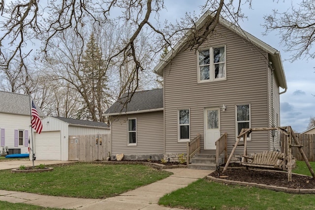 15 2nd St SE, Dodge Center, MN 55927 - view of front facade with fence, an outdoor structure, driveway, entry steps, and a front lawn