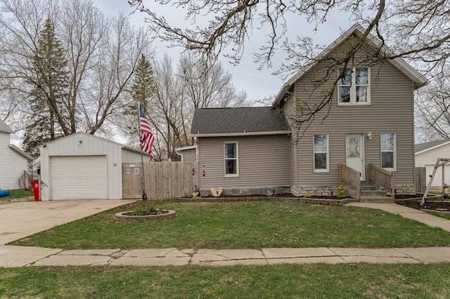 15 2nd St SE, Dodge Center, MN 55927 - view of front of house with fence, an outdoor structure, a garage, a front yard, and a shingled roof