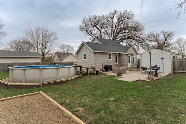 15 2nd St SE, Dodge Center, MN 55927 - back of property with a lawn, a fenced in pool, a patio, an outdoor fire pit, and a fenced backyard
