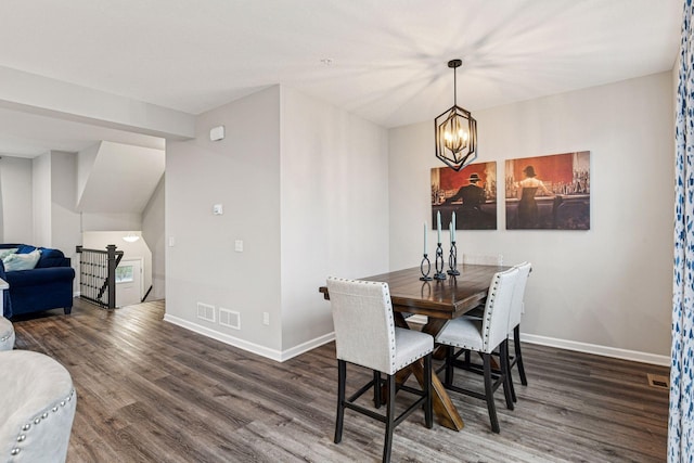 dining space with wood finished floors, baseboards, and a chandelier