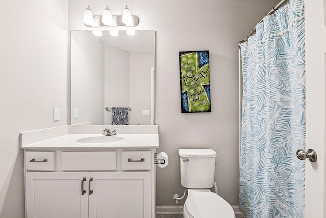 full bath with toilet, vanity, and baseboards