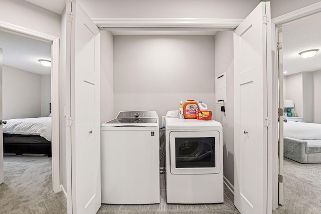 clothes washing area featuring carpet flooring and washer and dryer