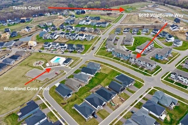 aerial view of property and surrounding area with nearby suburban area and a large body of water