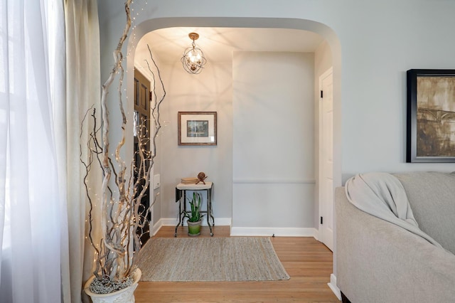 2102 Pinehurst Ave, Saint Paul, MN 55116 - corridor with arched walkways, wood finished floors, a chandelier, and baseboards