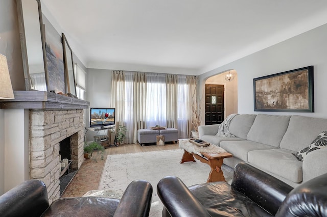 2102 Pinehurst Ave, Saint Paul, MN 55116 - living area featuring arched walkways, wood finished floors, and a stone fireplace