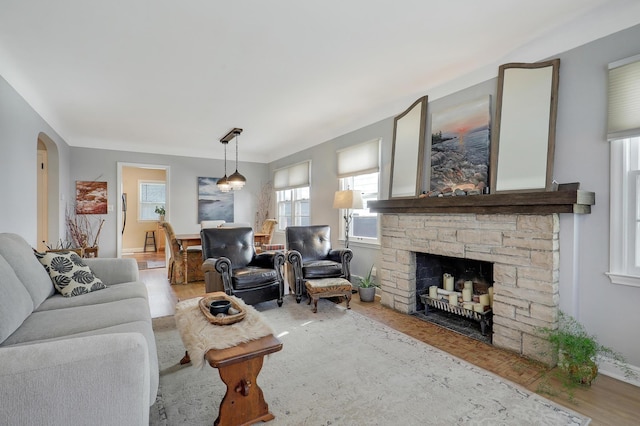 2102 Pinehurst Ave, Saint Paul, MN 55116 - living area with wood finished floors, a fireplace, arched walkways, and baseboards