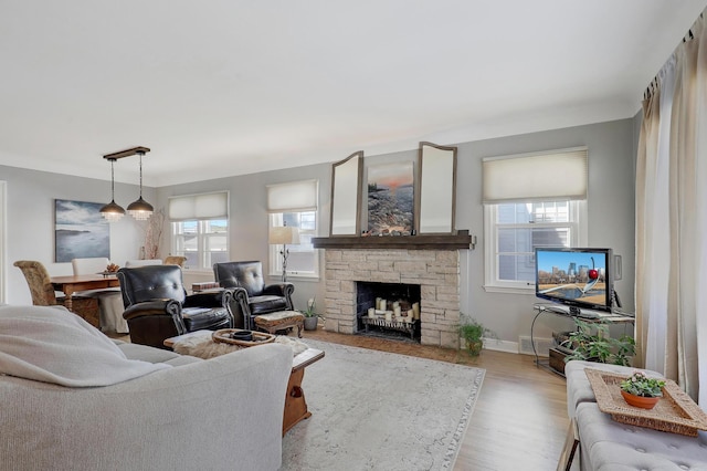 2102 Pinehurst Ave, Saint Paul, MN 55116 - living area featuring plenty of natural light, wood finished floors, a stone fireplace, and baseboards