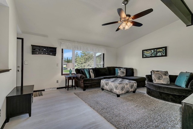 living area with visible vents, vaulted ceiling, light wood finished floors, a ceiling fan, and baseboards
