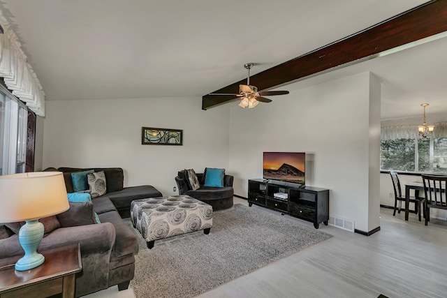 living room featuring wood finished floors, visible vents, vaulted ceiling, a ceiling fan, and baseboards