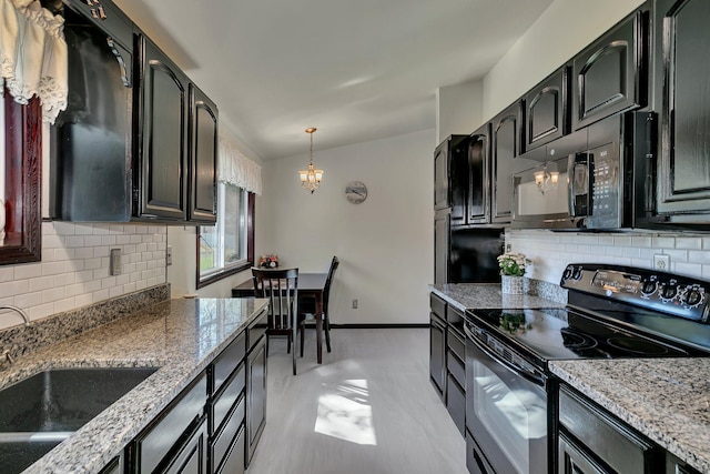 kitchen with a sink, light stone counters, black appliances, backsplash, and a notable chandelier