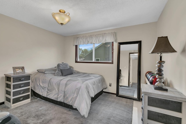 bedroom featuring a textured ceiling, carpet, and baseboards