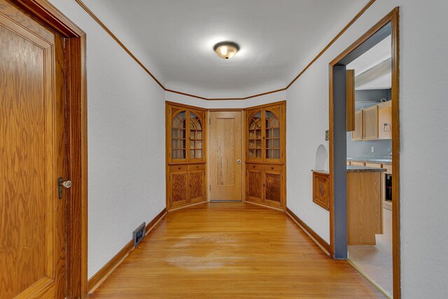 hallway featuring light wood-style floors and baseboards