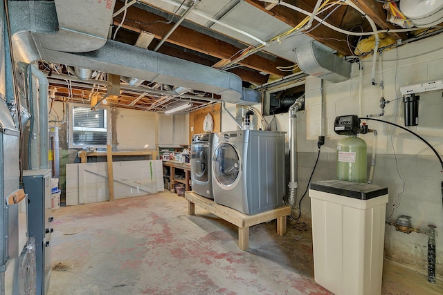 basement with washing machine and clothes dryer and a water softener