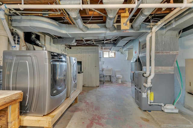 basement featuring washer and clothes dryer and a sink
