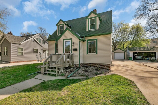 view of front of home with a garage, an outbuilding, a front yard, driveway, and a chimney