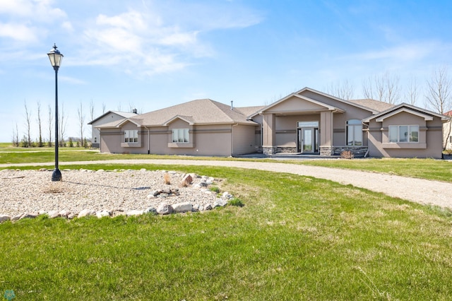 ranch-style house with stucco siding, a front lawn, and stone siding