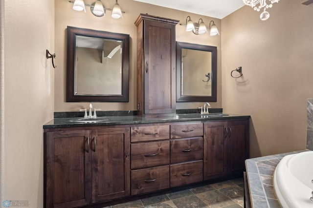 bathroom with double vanity, a bath, and stone finish flooring