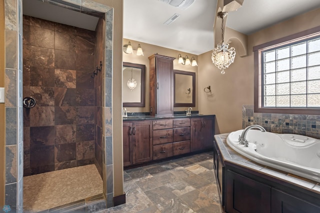 bathroom with a jetted tub, stone tile flooring, double vanity, tiled shower, and a chandelier