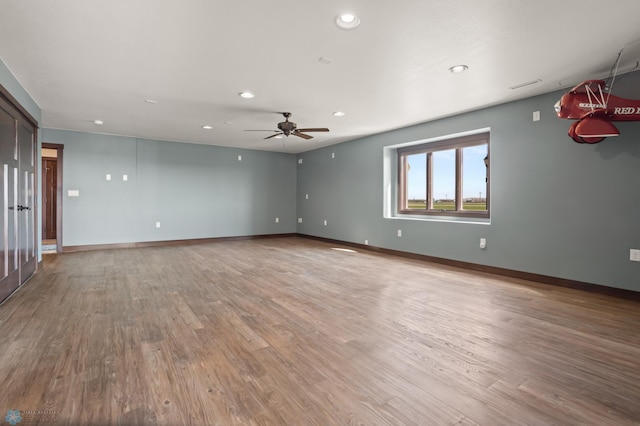 empty room featuring recessed lighting, a ceiling fan, wood finished floors, and baseboards