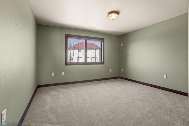 unfurnished room with carpet floors and baseboards