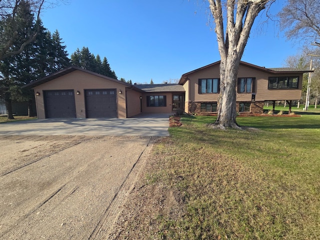 view of front of property featuring a garage, a front lawn, and driveway