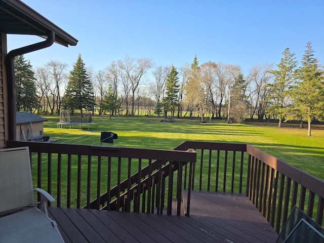 wooden deck with a trampoline and a yard