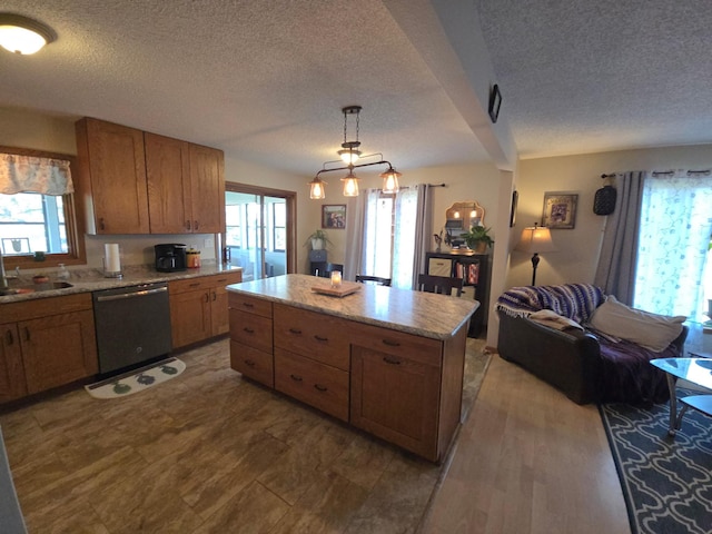 kitchen featuring a textured ceiling, a center island, a sink, and stainless steel dishwasher