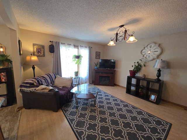 living room featuring a textured ceiling, wood finished floors, and a fireplace