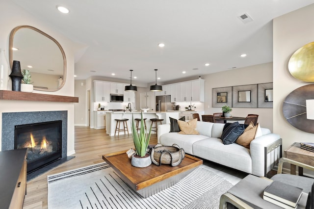 living area with recessed lighting, light wood-type flooring, and visible vents