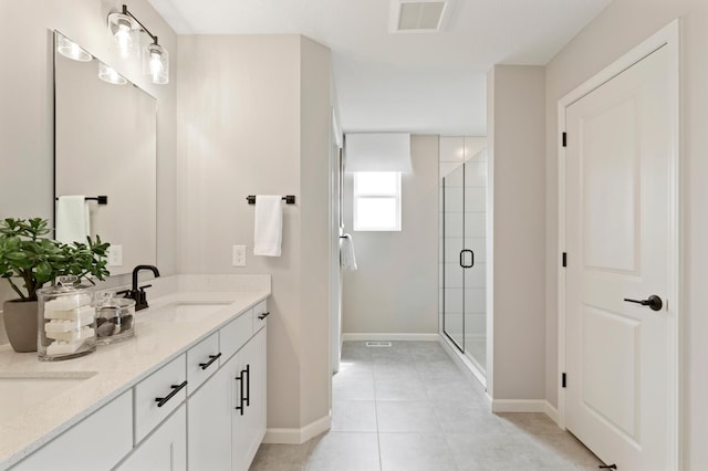 bathroom with a sink, baseboards, a stall shower, and visible vents