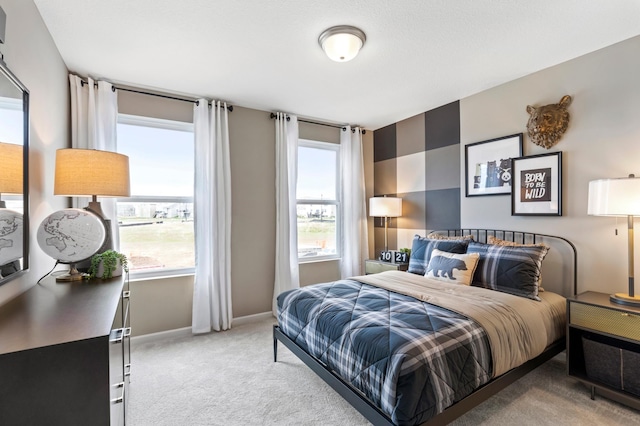 bedroom with baseboards and light carpet