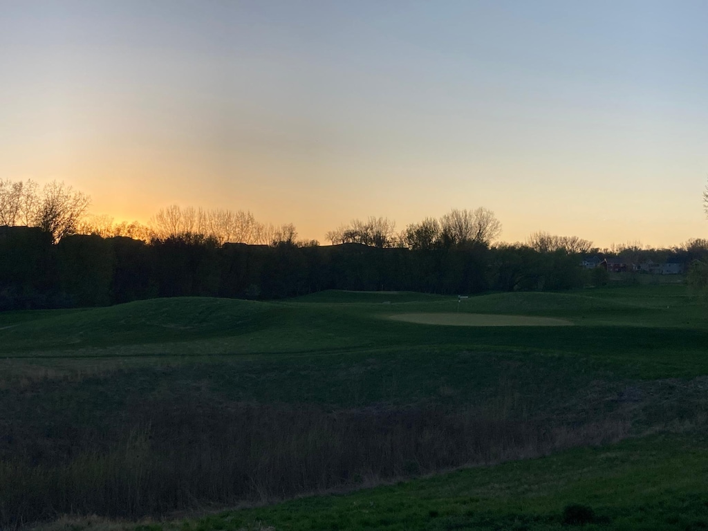 view of home's community featuring golf course view and a putting green