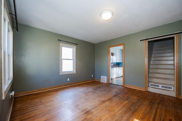 interior space with visible vents, baseboards, a baseboard radiator, and hardwood / wood-style flooring