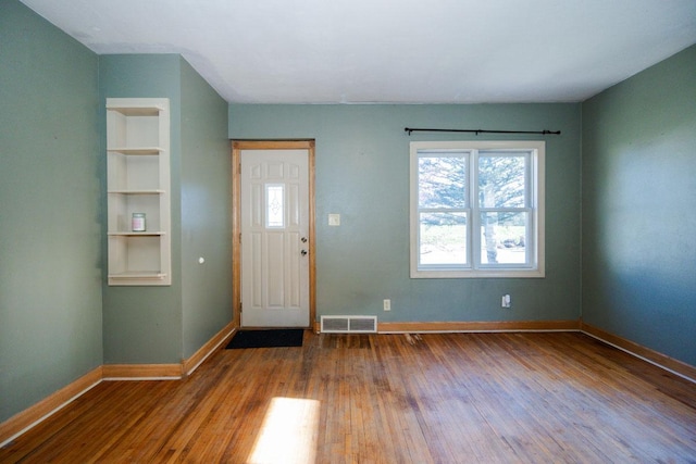 entrance foyer with visible vents, baseboards, and wood-type flooring