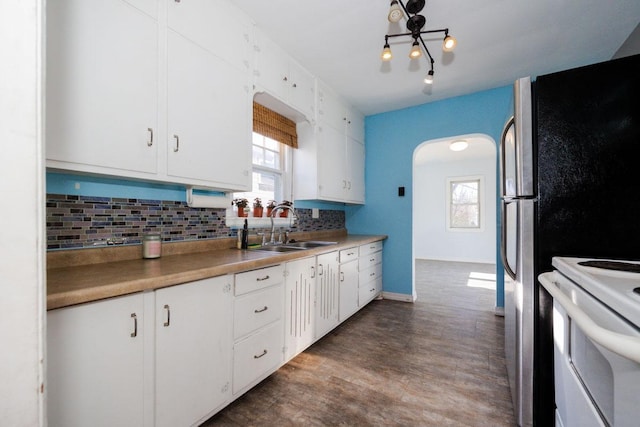 kitchen featuring white electric range, a sink, white cabinetry, tasteful backsplash, and dark wood-style floors