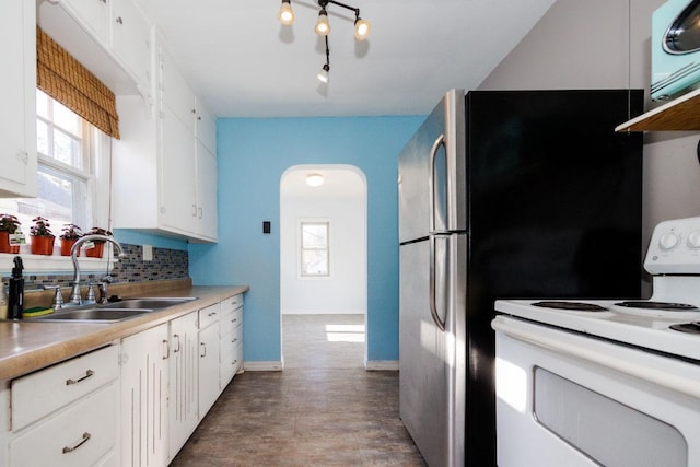 kitchen featuring a sink, white range with electric cooktop, white cabinetry, baseboards, and backsplash