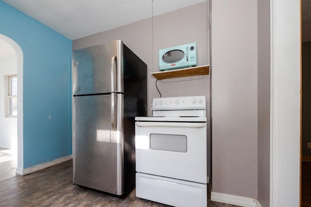 kitchen with freestanding refrigerator, baseboards, white range with electric cooktop, wood finished floors, and arched walkways