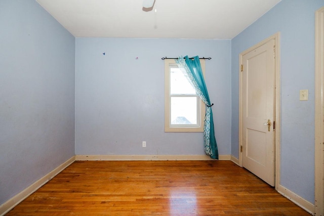 spare room featuring baseboards, a ceiling fan, and wood finished floors