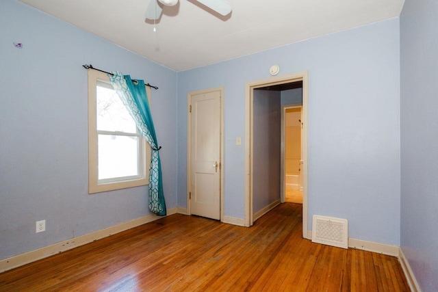unfurnished bedroom with visible vents, wood finished floors, and baseboards
